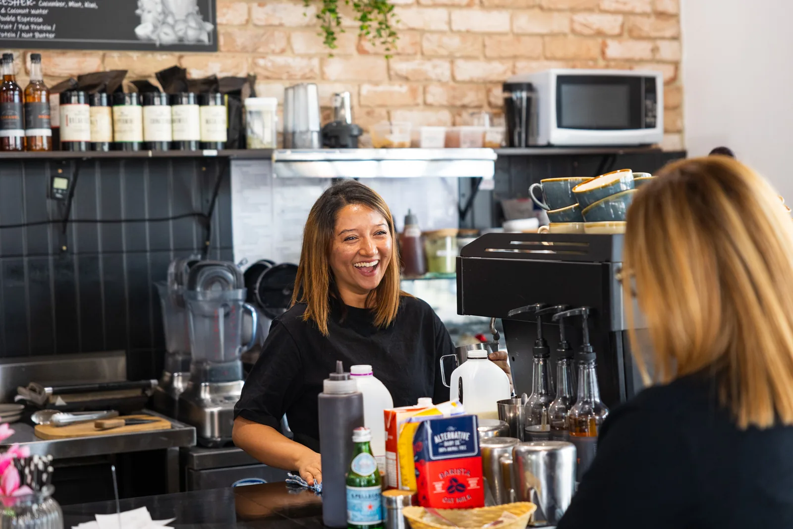 A staff member serving a customer at an EightyTwenty café