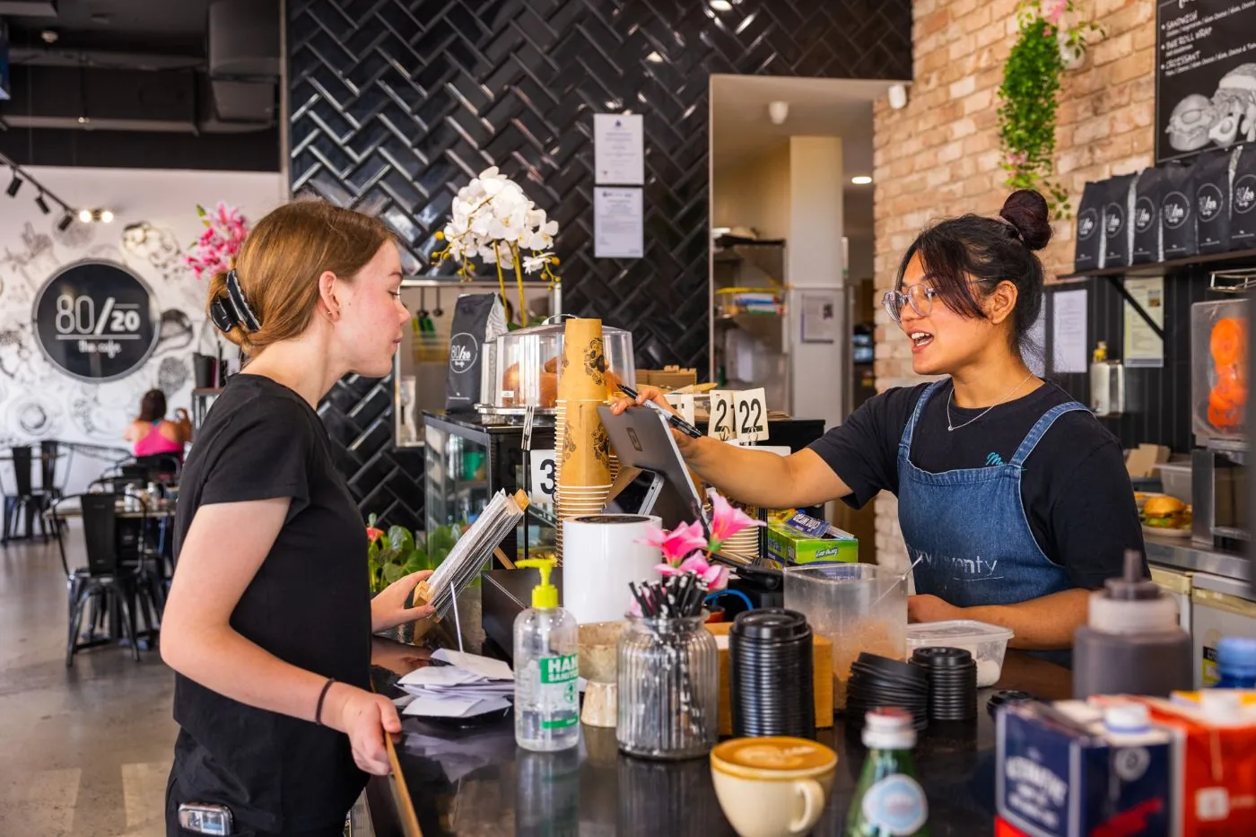 A barista serving a customer at the EightyTwenty counter
