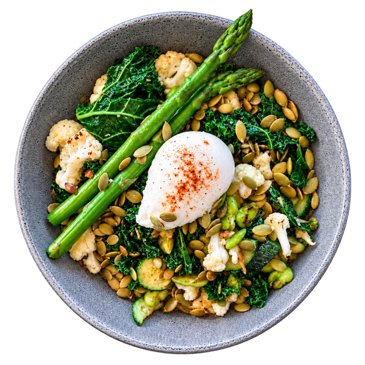 Green nourish bowl with kale, cauliflower, asparagus, pepitas and a poached egg, seen from above